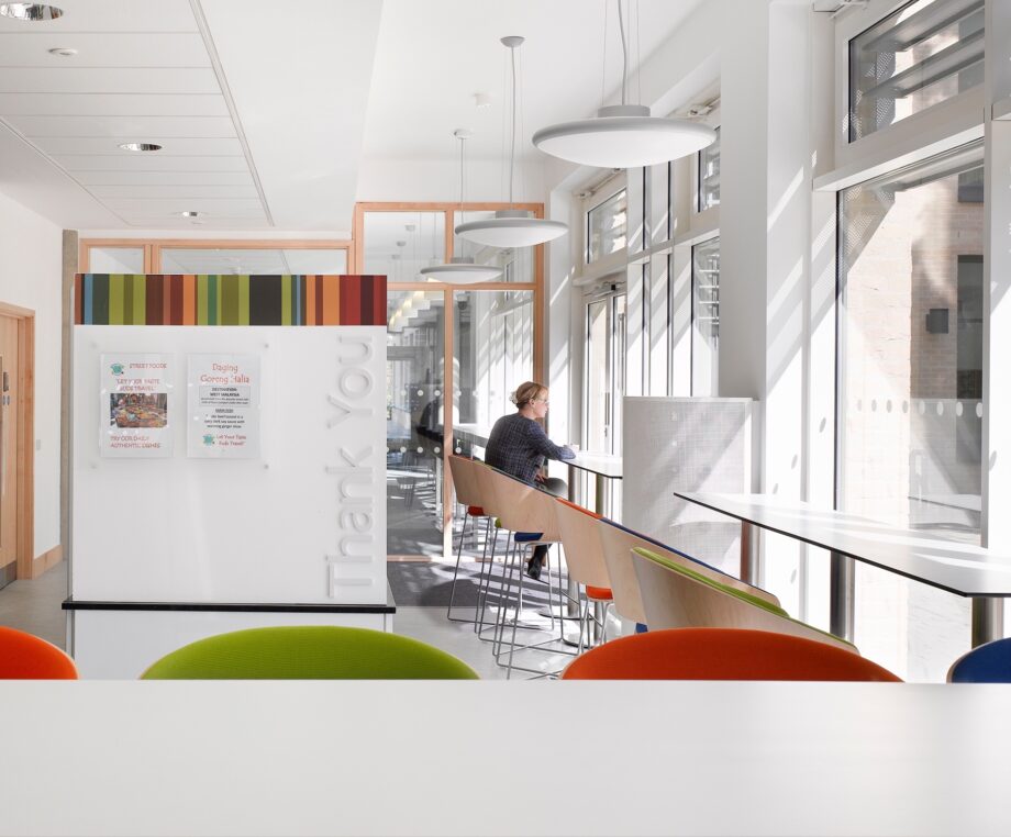 Inside the café area of the Alison Richard Building, with colourful chairs and window-side seats